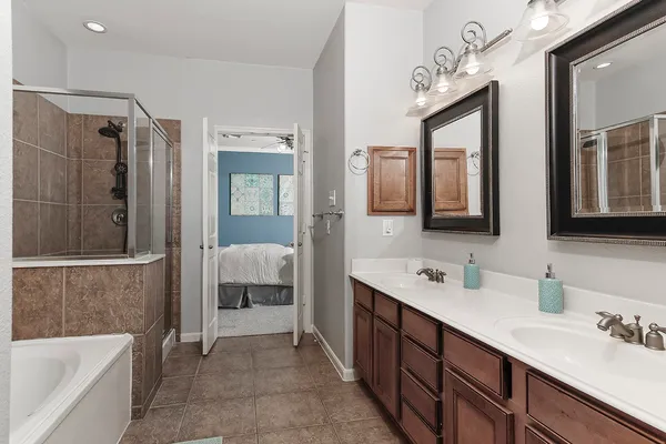 a spacious bathroom with a double vanity sink mirror and bathtub