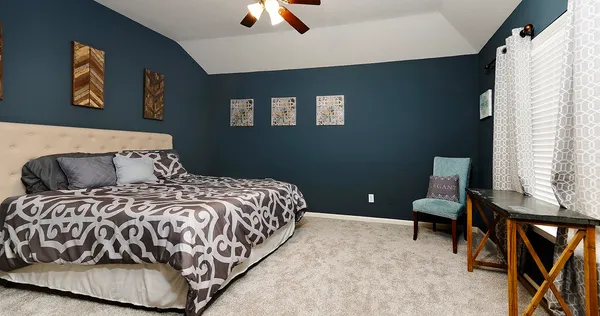 a bedroom with a bed and painting on the wall