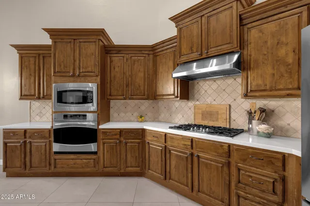 a kitchen with stainless steel appliances granite countertop a sink a stove and a refrigerator