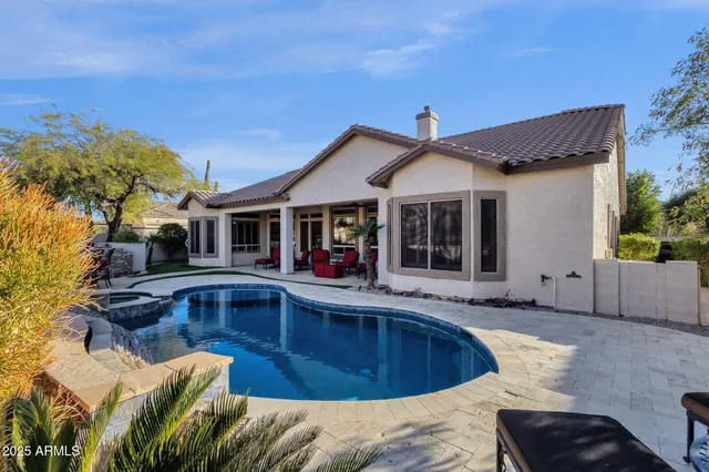 a view of a house with backyard fountain and sitting area