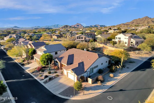 an aerial view of residential houses with outdoor space and trees