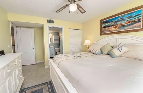 a spacious bedroom with a bed and a chandelier