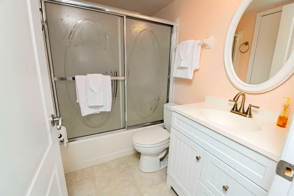 a bathroom with a granite countertop sink toilet and shower