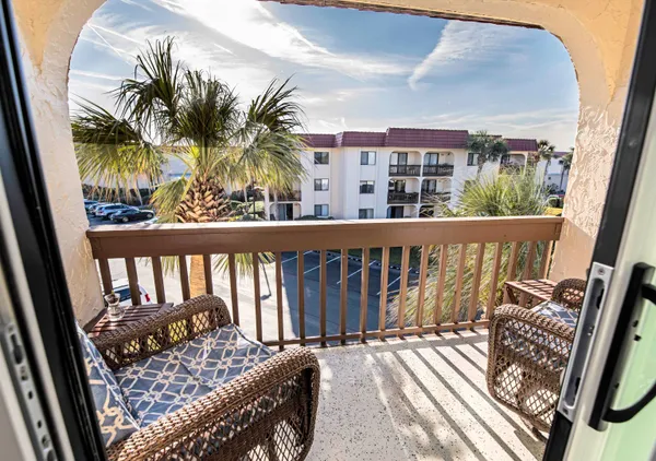 a balcony with wooden floor table and chairs