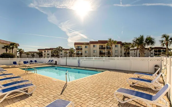 a living room with furniture a rug and kitchen view