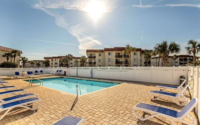 a living room with furniture a rug and kitchen view