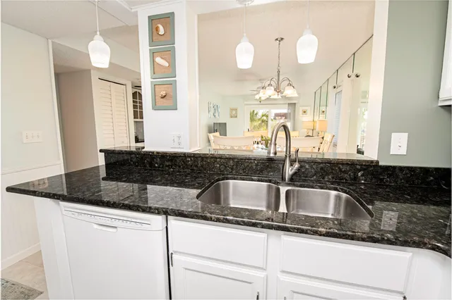 a kitchen with granite countertop a sink and cabinets