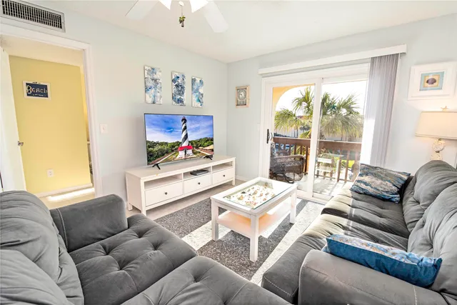 a living room with furniture a large window and a flat screen tv