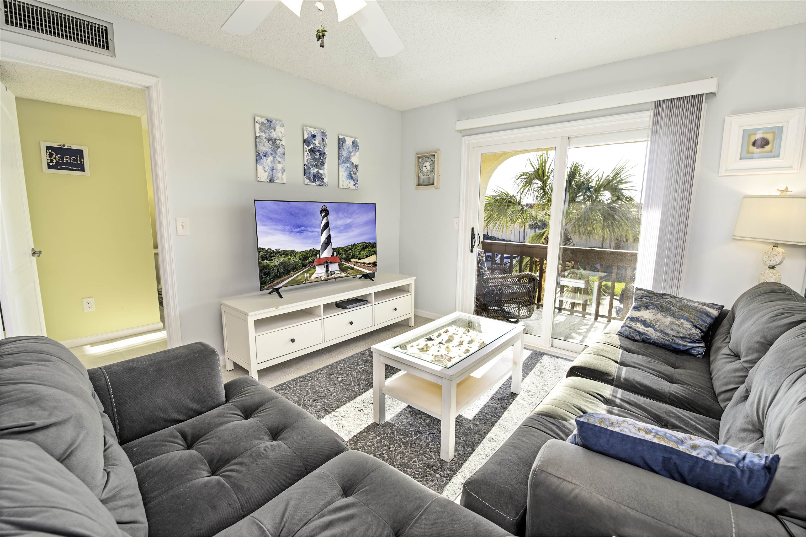 880 A1A Beach Boulevard, Unit 7302 St. Augustine, FL 32080 - Photo 10 of 28 a living room with furniture a large window and a flat screen tv