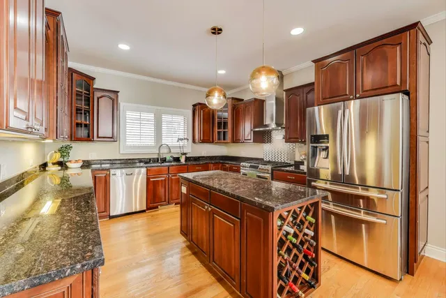 a kitchen with stainless steel appliances granite countertop a sink a stove and a refrigerator