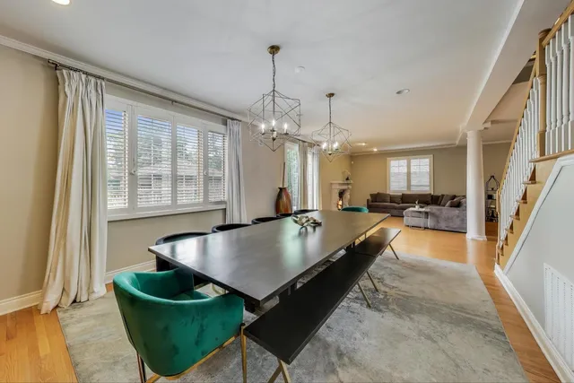 a view of a dining room and livingroom with furniture wooden floor a chandelier