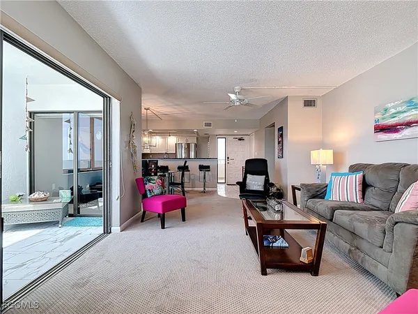 a kitchen with stainless steel appliances kitchen island granite countertop a refrigerator a stove a sink dishwasher and white cabinets with wooden floor