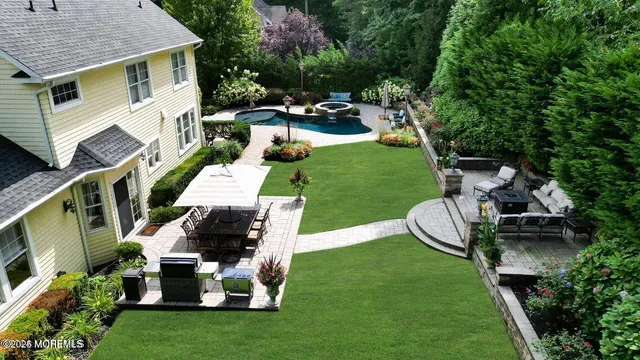 a view of a patio with table and chairs potted plants and large tree
