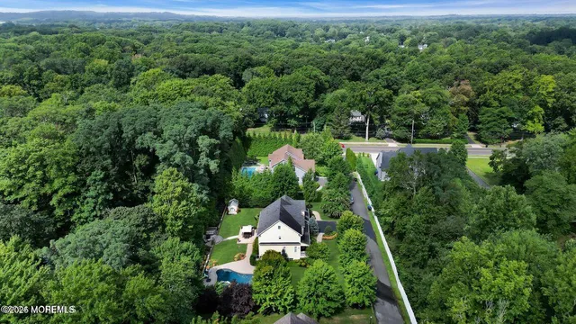 an aerial view of residential house with outdoor space and trees all around