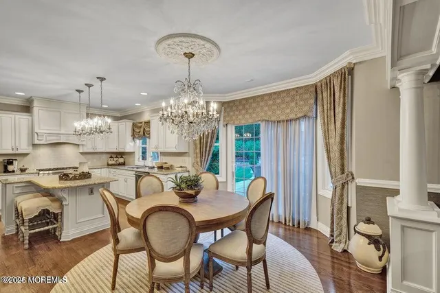 a view of a dining room with furniture a chandelier and wooden floor