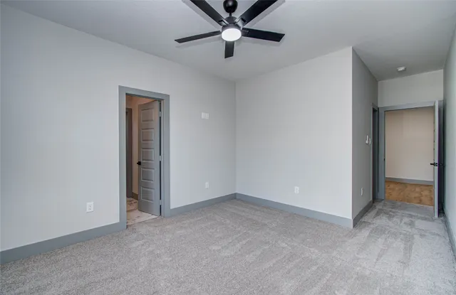 an empty room with closet and a ceiling fan