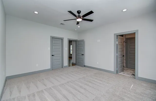 an empty room with closet and ceiling fan