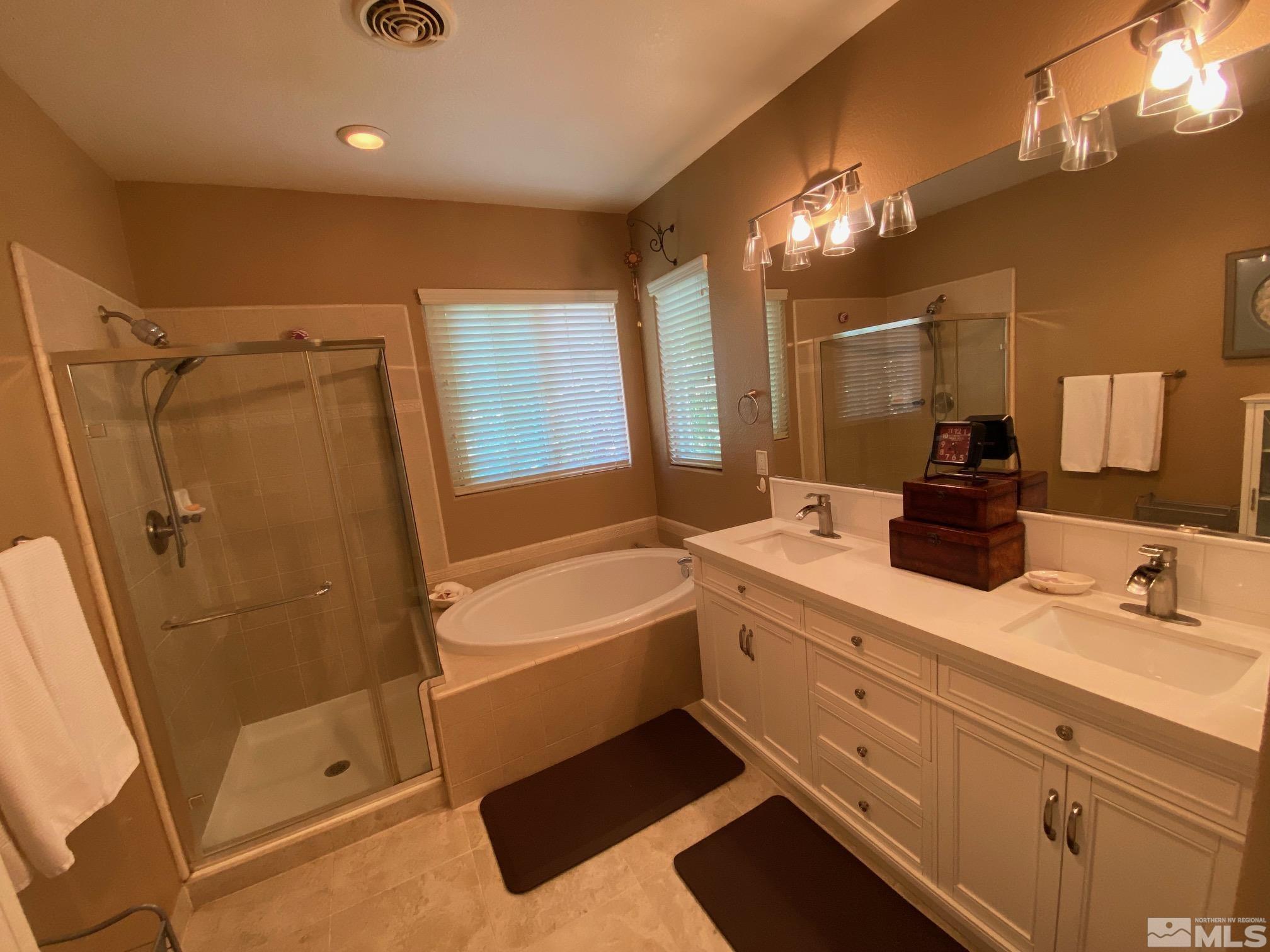 7875 Morgan Pointe Circle Reno, NV 89523 - Photo 22 of 31 a bathroom with a double vanity sink a large mirror and shower