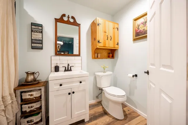 a bathroom with a toilet a sink and mirror
