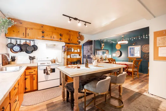 a kitchen with a stove a refrigerator and a dining table