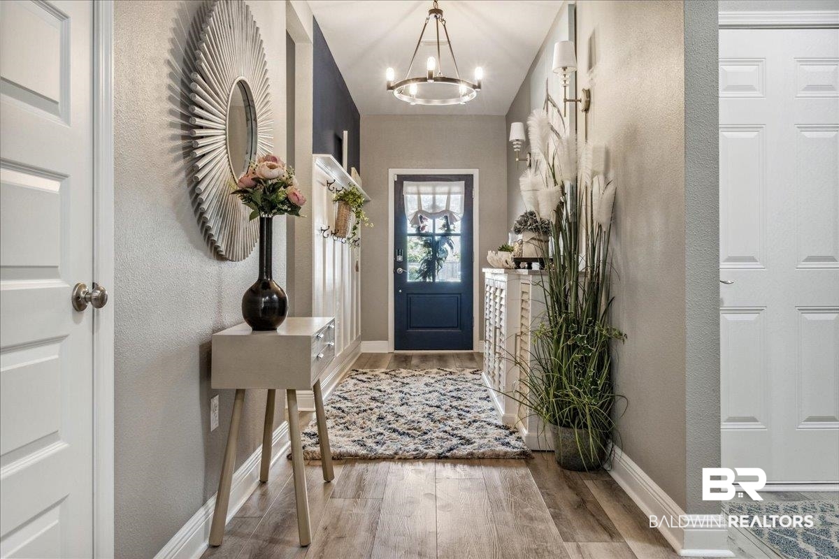 7022 Rocky Rd Loop Gulf Shores, AL 36542 - Photo 6 of 59 Entryway with a chandelier, light wood finished floors, and a textured wall