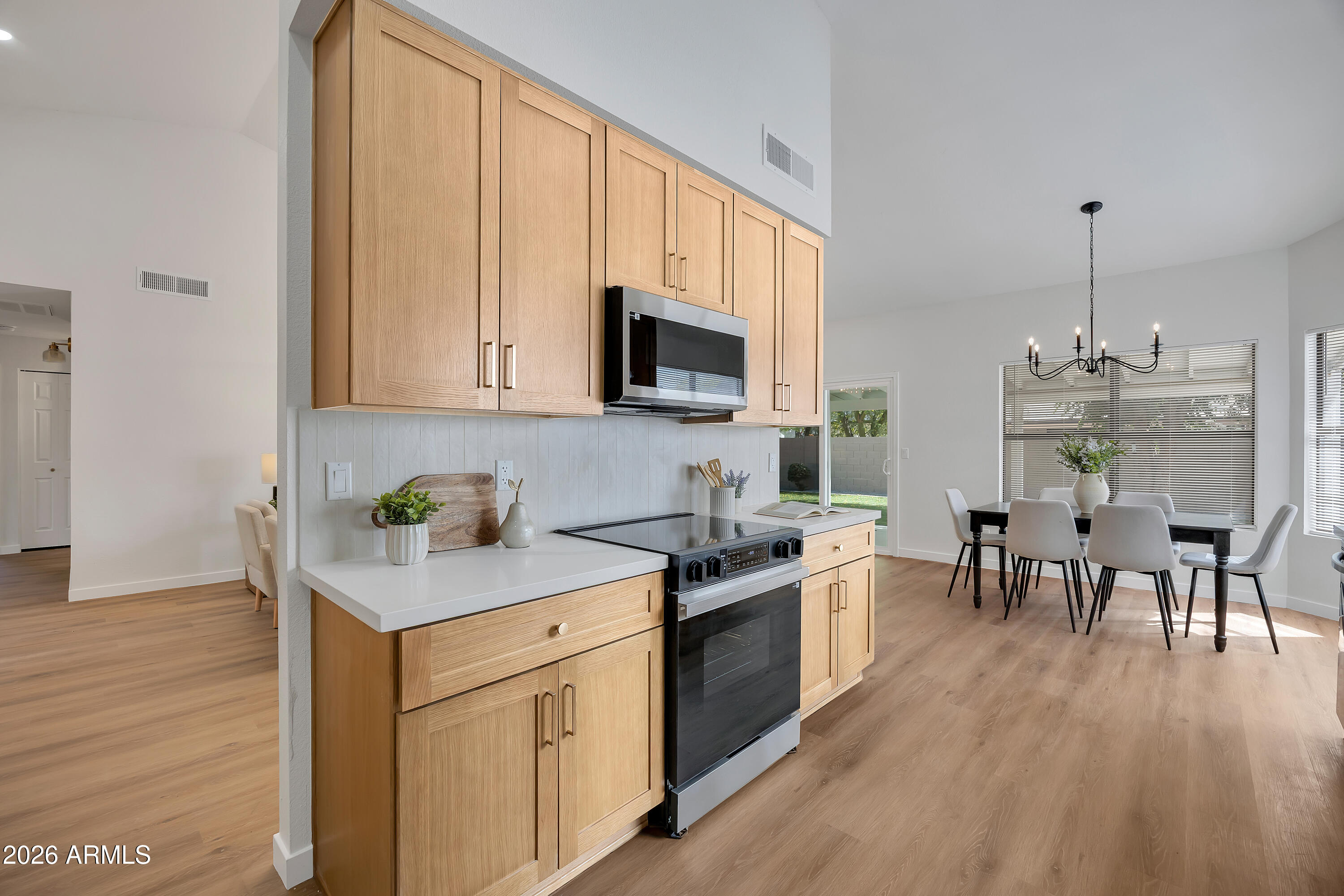 613 West Tara Court Gilbert, AZ 85233 - Photo 12 of 25 a kitchen with stainless steel appliances granite countertop wooden floors a stove top oven a granite counter tops and a view of living room