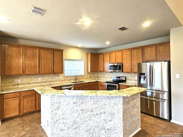 a kitchen with a refrigerator a stove a sink and a microwave