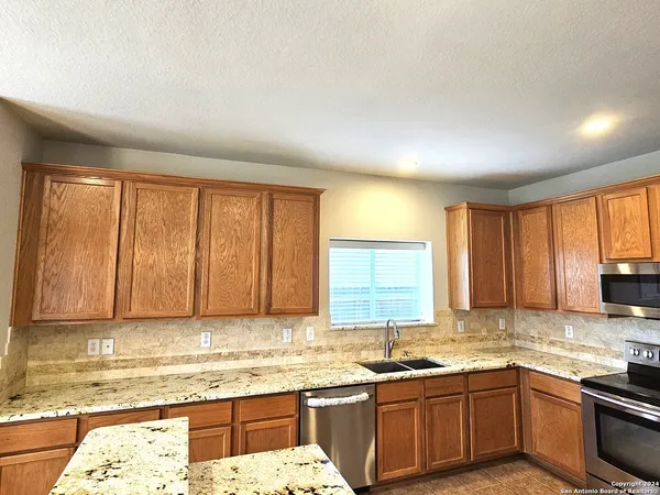 a kitchen with a sink stove and cabinets