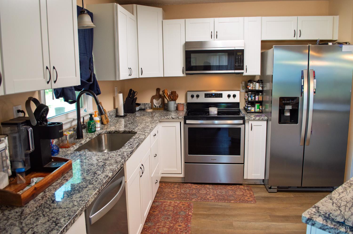 95 Midgett Farm Road Concord, VA 24538 - Photo 6 of 20 a kitchen with granite countertop a refrigerator stove and microwave