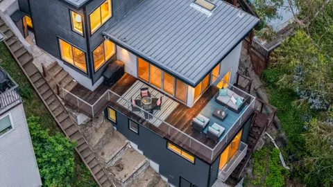 an aerial view of a house with balcony and trees al around