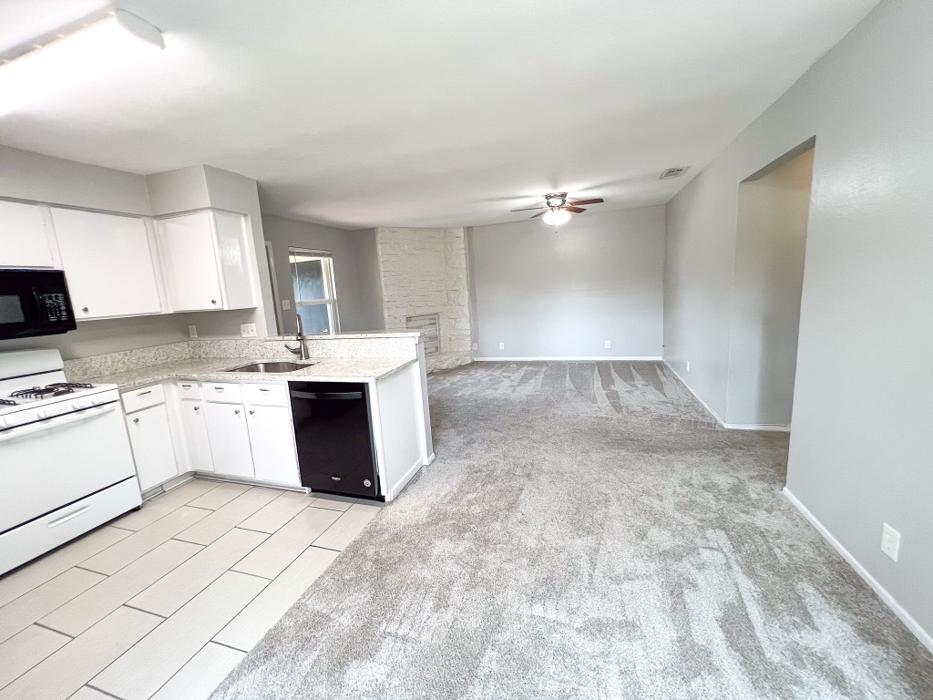 9703 Roxanna Drive, Unit D Austin, TX 78748 - Photo 18 of 24 Kitchen featuring black appliances, white cabinets, a peninsula, light carpet, and ceiling fan