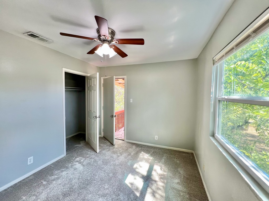 9703 Roxanna Drive, Unit D Austin, TX 78748 - Photo 21 of 24 Unfurnished bedroom with carpet, a closet, and ceiling fan. This bedroom has access to the balcony.