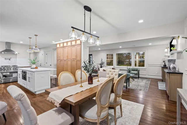 a dining room with furniture a chandelier and wooden floor