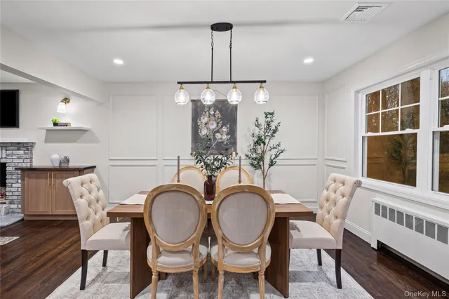 a dining room with furniture a chandelier and wooden floor