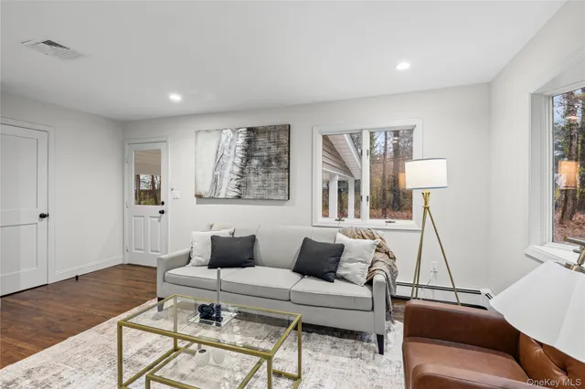a living room with furniture and a wooden floor