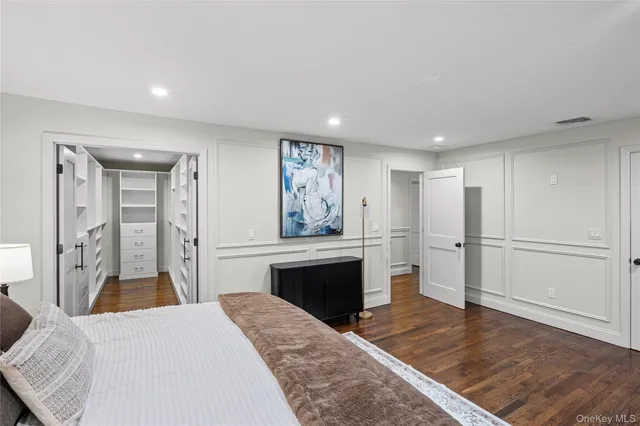 a spacious bedroom with a bed and a flat screen tv