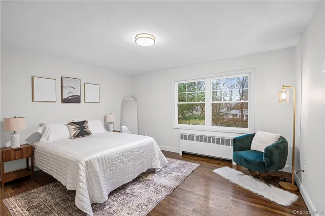 a bedroom with a bed wooden floor and a window