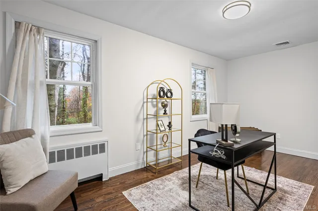a view of a workspace with furniture and a window
