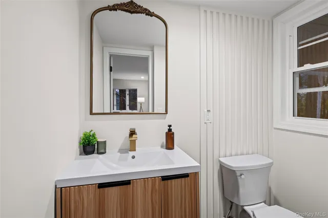 a bathroom with a sink a toilet and mirror