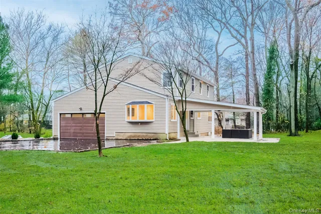 a front view of a house with a garden and trees