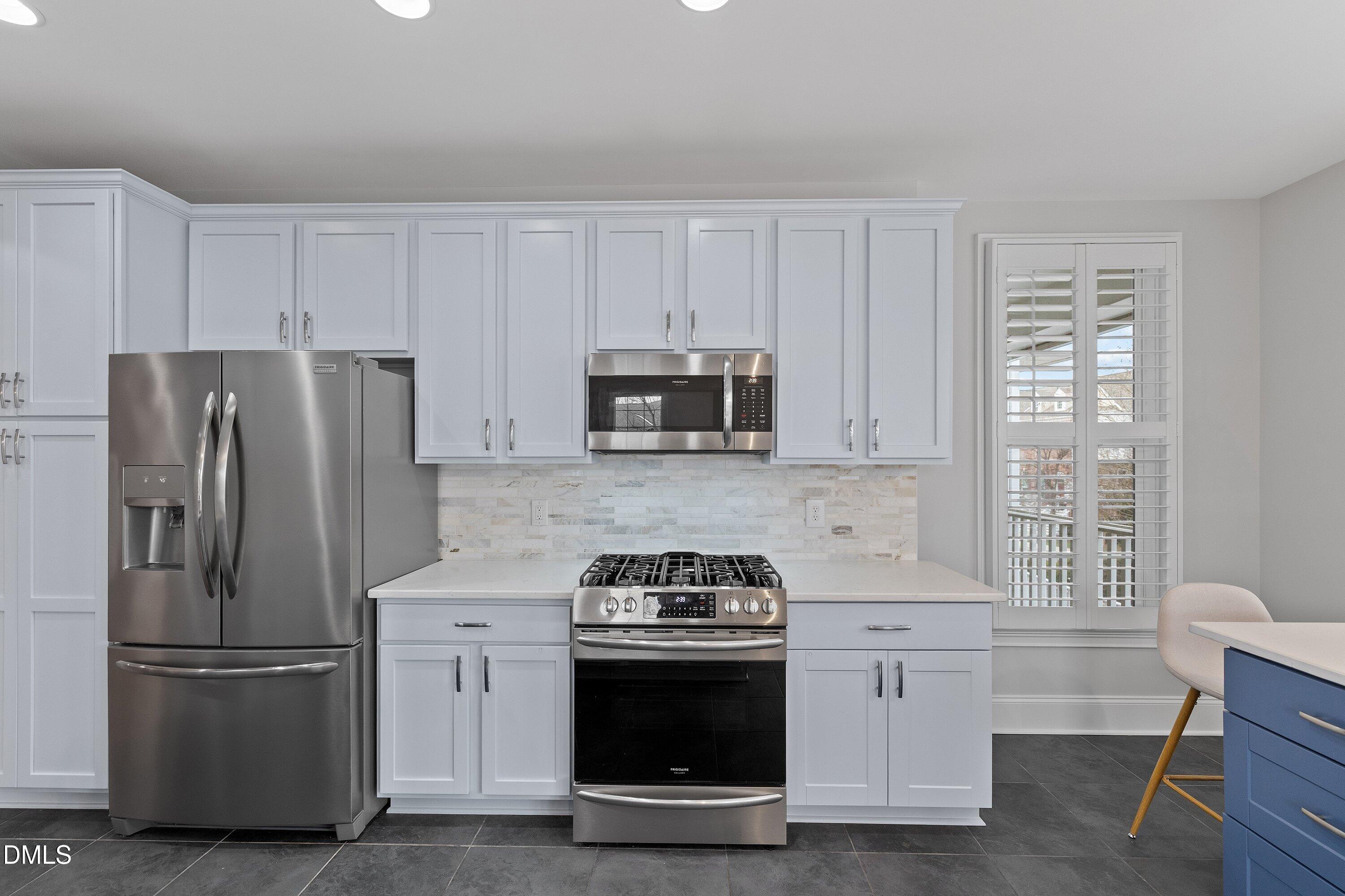 9211 Calabria Drive, Unit 205 Raleigh, NC 27617 - Photo 20 of 55 a kitchen with stainless steel appliances white cabinets and a stove top oven