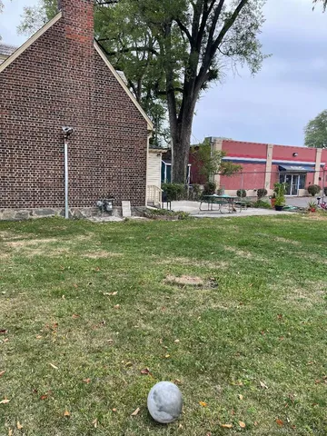 a view of a backyard with table and chairs and a fire pit