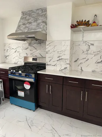 a kitchen with granite countertop a stove and cabinets