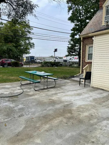 a view of swimming pool with a table and chairs under an umbrella