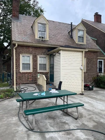 a view of a white house with a bench