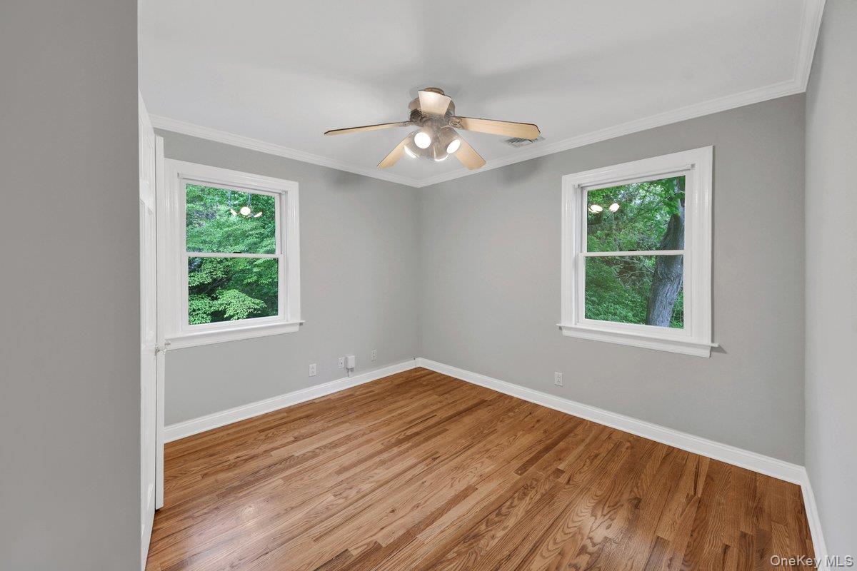 7 Rutledge Road Valhalla, NY 10595 - Photo 21 of 37 Bright room featuring two windows, wood-finish flooring, a ceiling fan, crown molding, and painted walls