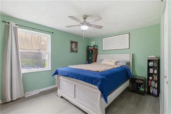 a bedroom with a bed and a flat tv screen on dresser