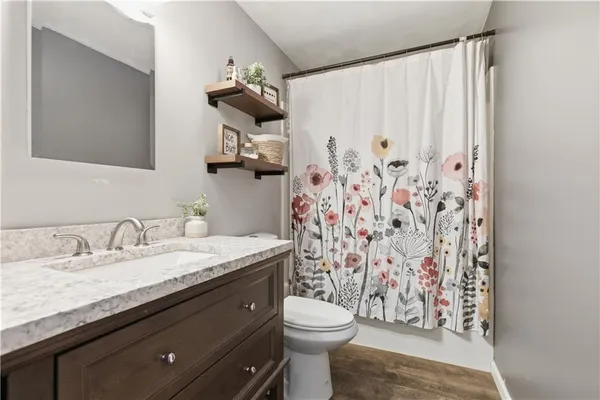 a bathroom with a granite countertop toilet a sink and a mirror
