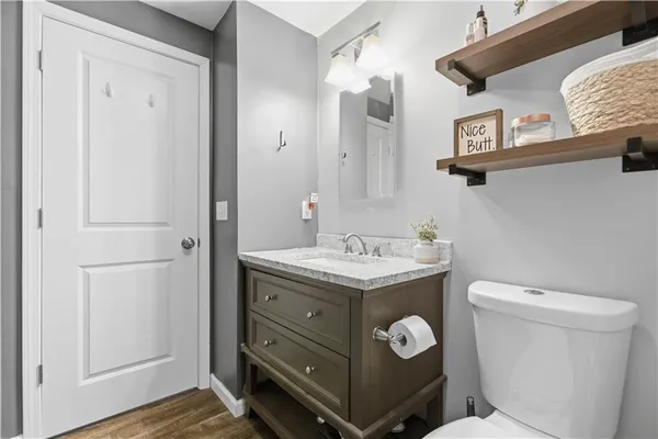 a bathroom with a toilet a sink and mirror