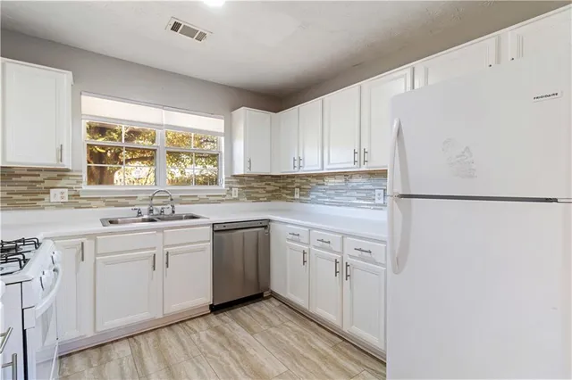 a kitchen with granite countertop white cabinets and white appliances